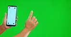 Hands, phone and mockup touch on green screen for social media advertising against a studio background. Hand of person with mobile smartphone, mock up display and tracking markers for advertisement