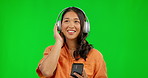 Phone, radio headphones and woman on green screen in studio isolated on a background mockup. Music, listening and happy Asian person streaming audio, sound or podcast, jazz and dancing to hip hop.