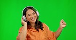 Dancing, music headphones and woman on green screen in studio isolated on a background. Radio, listening and happy Asian person streaming audio, sound or podcast, jazz playlist and dance with energy.