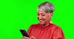 Phone, happy and senior woman on green screen for conversation, chatting and mobile app. Communication, network and female person typing on smartphone for social media, internet and email in studio