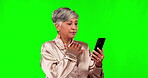 Phone, reading and bad news with a woman on a green screen background in studio thinking about a message. Reaction, contact and a senior female person checking a mobile notification on chromakey