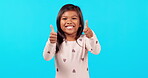 Happy little girl, thumbs up and success on mockup for good job against a blue studio background. Portrait of female person, child or kid with smile and thumb emoji, yes sign or like for approval