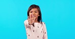 Hand, stop and girl child face in studio with warning, reject or no sign, forbidden or wrong on blue background. Palm, emoji and kid portrait with protest, vote or choice of defense or showing limits