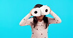 Children, toilet paper binoculars and a girl on a blue background in studio for fun in her pajamas. Kids, comic and funny with an adorable female child playing or joking for humor at bedtime