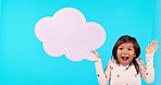 Speech bubble, shock and face of girl in studio for announcement, news and information. Advertising, social media and portrait of excited child with banner, poster and billboard on blue background