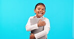 School, books and portrait of child excited for education or homework isolated in a studio blue background. Learning, development and kid or young girl happy in uniform holding textbook with a smile