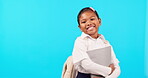 School, books and portrait of girl excited for education or homework isolated in a studio blue background. Learning, development and kid or young child happy in uniform holding textbook with a smile