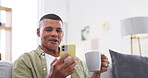 Phone, coffee and social media with a man laughing at a meme on a sofa in the living room of his home. Mobile, relax and funny with a happy male person reading a comic or joke online for humor