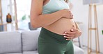 Pregnant woman, stomach rubbing and hands at home with baby love, support and relax care. Young female person, belly development and mom with maternity growth and pregnancy in a house living room