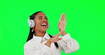 Happy woman, dancing and headphones listening to music on green screen against a studio background. Female person with headset in happiness enjoying audio streaming, beats or online sound track