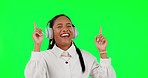 Happy woman, headphones and laughing listening to music on green screen against a studio background. Female person with headset in dance and happiness enjoying audio streaming or online sound track