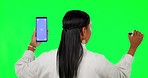 Woman, phone mockup and writing on green screen for planning against a studio background. Back of female person thinking on chromakey space or mobile smartphone app, display and tracking markers