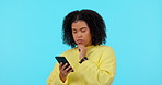 Review, thinking and happy with woman and phone on studio for social media, website and email. Technology, planning and news with female person on blue background for idea, search and networking