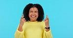 Excited, hope and a woman with fingers crossed on a blue background isolated with motivation in a studio. Happy, trust and a young girl with a wish, waiting and hopeful with a hand gesture