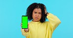 Woman, phone and angry in studio with glitch, error and green screen with mockup space by blue background. African student girl, smartphone and stress on face for internet, software update or mistake