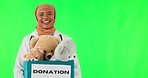Teddy bear donation, doctor and Muslim woman on green screen in studio isolated on background. Face, portrait and charity toys with medical professional for gift, funny balloons or community service.