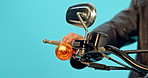 Travel, vintage and hand of man on motorcycles in studio for retro, speed and leather. Freedom, fast and adventure with closeup of person motorbike on blue background for transportation and road trip