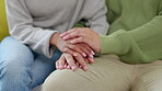 Support, couple holding hands and closeup together on a sofa for empathy. Love or sympathy, comfort or praying for healing and people hold hand for respect or forgive sitting on a couch for apology