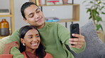 Couple, selfie and happy, love and relax on couch, interracial with trust and support in relationship. Young people bonding at home together, smile and posing in picture for social media post