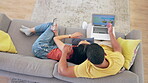 Laptop, holiday planning and a couple on a sofa in the living room of their home together from above. Computer, phone or technology with a young man and woman searching for a vacation destination