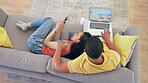 Laptop, vacation planning and a couple on a sofa in the living room of their home together from above. Computer, phone or technology with a young man and woman searching for a holiday destination