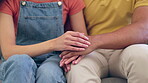 Hands, love and empathy with a couple on a sofa in the living room of their home together for support. Trust, anxiety or mental health with a man and woman consoling through pain, loss or grief