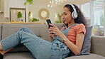 Woman, phone and headphones on sofa dancing, audio streaming and listening to audio, hip hop radio and home break. Relax, couch and young person for gen z music, electronics and mobile in living room