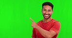 Pointing, mockup and face of Asian man on green screen for promotion, branding and selection. Advertising, hand gesture and portrait of happy male person with deal, news and announcement in studio