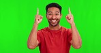 Pointing up, excited and face of Asian man on green screen for promotion, branding or selection. Advertising, hand gesture and portrait of happy male person with deal, news and announcement in studio