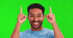 Happy asian man, hands and pointing up on green screen for advertising against a studio background. Portrait of male person face, smile and show for marketing, notification or news on mockup space