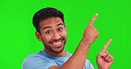 Pointing, excited and face of Asian man on green screen for promotion, branding and selection. Advertising, hand gesture and portrait of happy male person with deal, news and announcement in studio