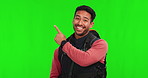 Asian man, backpack and pointing on green screen for advertising or travel against a studio background. Portrait of happy male person or traveler show notification for marketing on mockup space