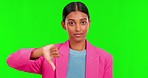 Thumbs down, finger and face of indian woman on green screen, studio and shake head for wrong sign, bad review and fail. Portrait, hand and female model with dislike emoji, feedback and hate opinion