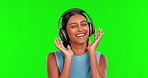 Happy woman, headphones and listening to music on green screen in dance against a studio background. Portrait of female person smile with headset for audio streaming, songs or sound track on mockup