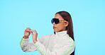 Fashion, future and metaverse with a woman in a vr headset isolated on a blue background in studio. Virtual reality, cyberpunk and ai technology with a young female user wearing cyber eyewear