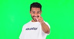 Pointing, calling and volunteering Asian man on a green screen for recruitment and choice. Happy, portrait and a male volunteer with a gesture for charity service isolated on mockup studio background