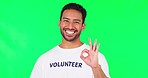 OK sign, volunteer and man on green screen for charity, community service and nonprofit support or goals. Yes, okay and emoji hands, happy face and asian person in NGO for change on studio background