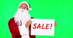 Sale poster, Christmas and Santa Claus on green screen for holiday, festival and celebration. Advertising, festive season and portrait of male person with sign for discount, bargain or deal in studio