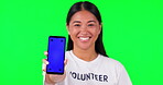 Phone, green screen and portrait of volunteer woman with charity website fund information mockup. Asian person hand with smartphone and tshirt for nonprofit contact, NGO or donation tracking markers