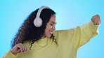 Dance, music headphones and happy woman in studio isolated on a blue background. Radio, listening and smile of person singing, streaming audio or sound for jazz podcast, hip hop and rock with energy