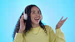 Dancing, music headphones and happy woman in studio isolated on a blue background. Radio, listening and smile of person singing, streaming audio or sound for jazz podcast, hip hop or rock with energy