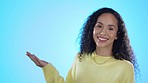 Smile, woman face and hand pointing in studio for coming soon, news or announcement on blue background. Finger, portrait and female person happy with timeline, checklist or information, promo or faq