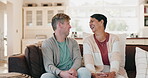 Family, funny and a man talking to his mother on a sofa in the living room of their home during a visit. Love, conversation and comedy with a senior woman chatting to her adult son in a house