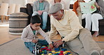 Family, building blocks and a granddad playing with his grandson in the living room of a home during a visit. Children, love or toys with a senior man bonding with his boy grandkid on the floor