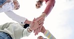 Family, hands together and team in solidarity below for collaboration or celebration under sky. Low angle of mother, father and kids piling for teamwork motivation, support or coordination together