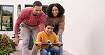 Parents, kid and learning to ride a bike, bicycle or teaching child to cycle, drive or cycling in childhood memory. Mom, dad and son riding at home, house or playing in outdoor garden with family