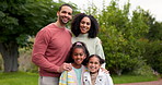 Mother, father and happy family portrait outdoor with a smile, love and care in nature. Young latino woman and man or parents and kids together at a park or garden for quality time, peace and fun