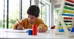 Home learning, math education or boy in kindergarten studying for knowledge or growth development. Focus, assessment or smart child writing or counting on numbers to study for test in notebook alone