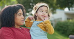 Family, children and a woman with her adopted daughter in the garden of their foster home together. Love, smile and kids with a happy mother holding her female child outdoor in the home backyard