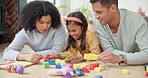 Building blocks, happy and parents playing with their child on the floor in the living room. Happiness, smile and girl kid learning with toys with young mother and father in their modern family home.